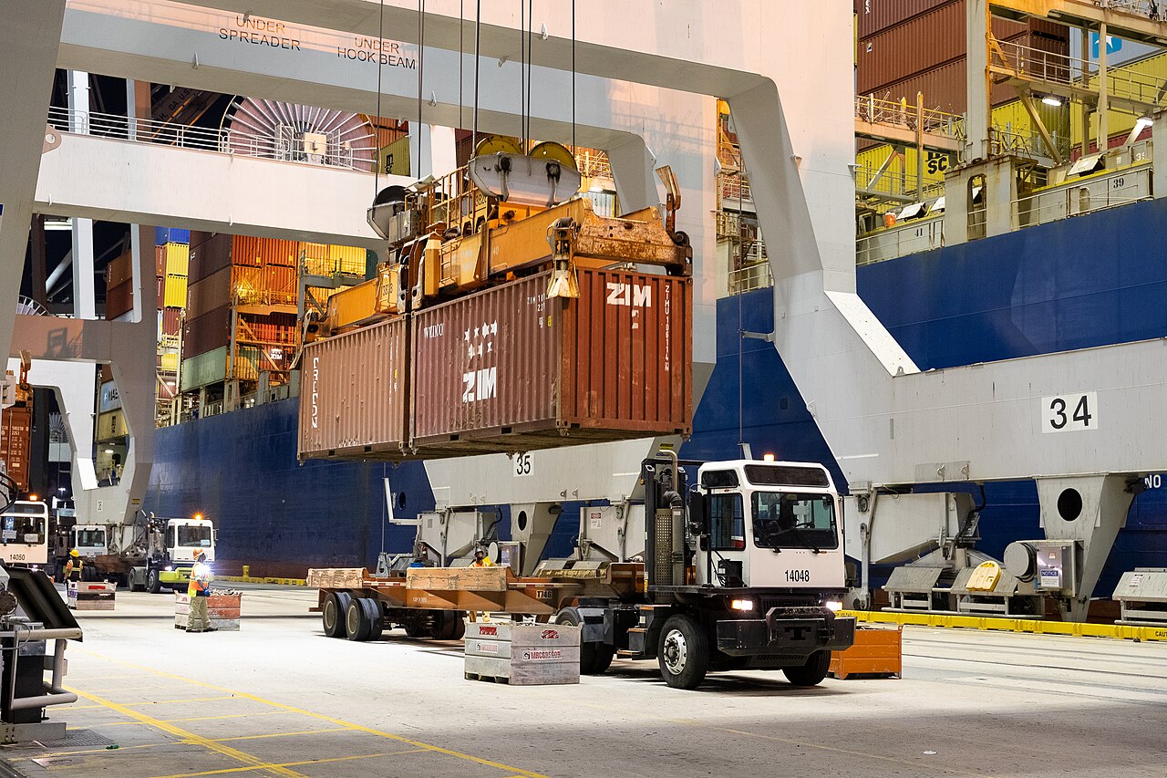 A quay crane lowers a shipping container beside a cargo ship at the Port of Savannah in 2021